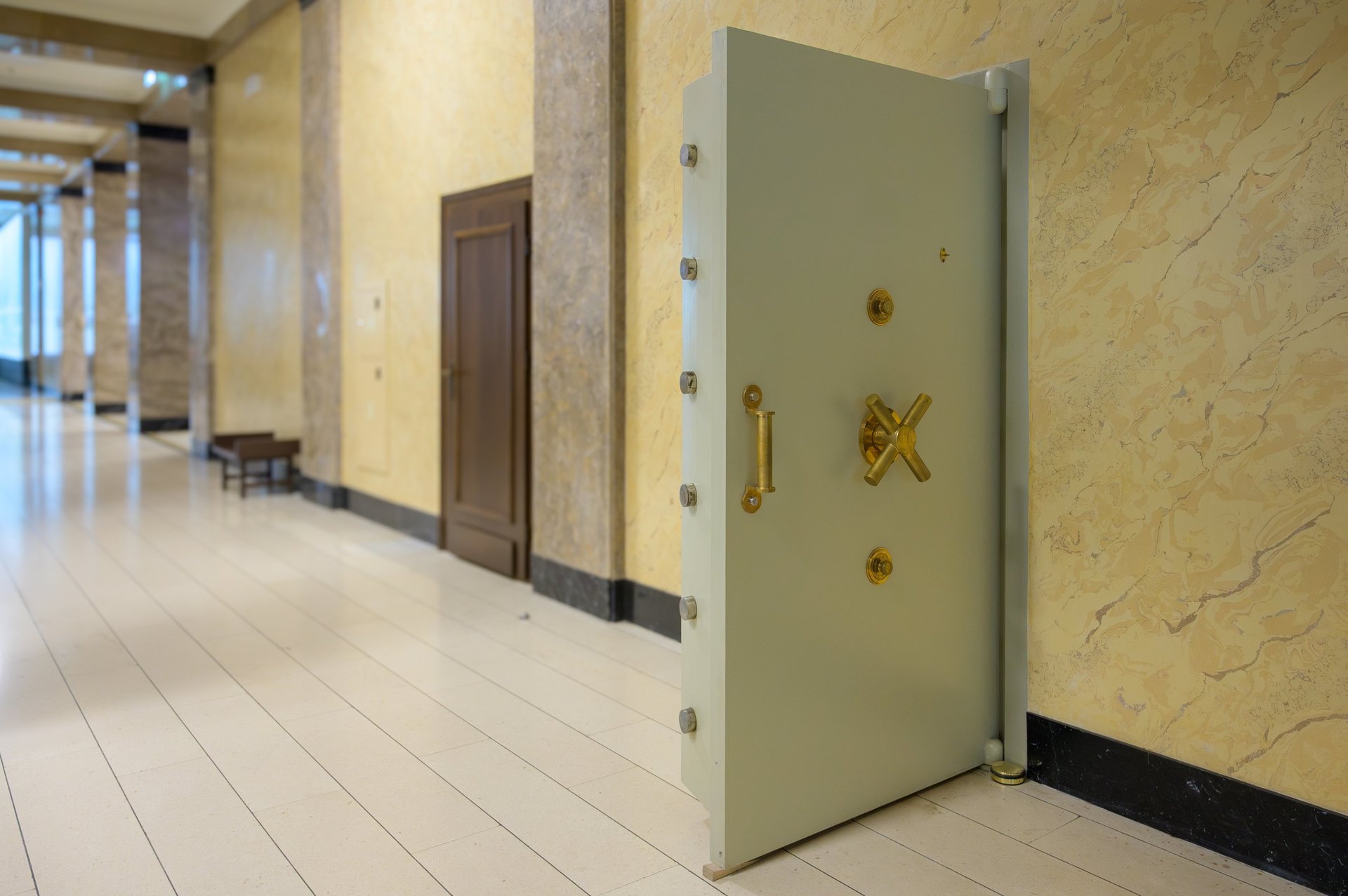Sturdy vintage safe door in bank corridor